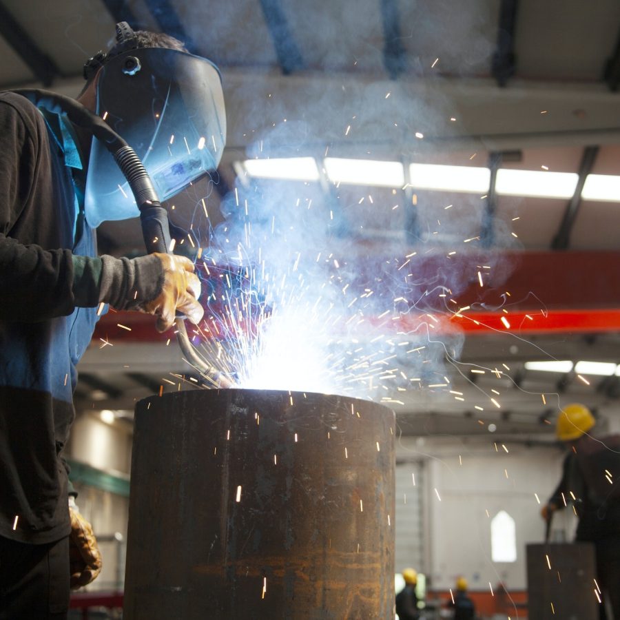 Welder working in a factory. Metal industry.